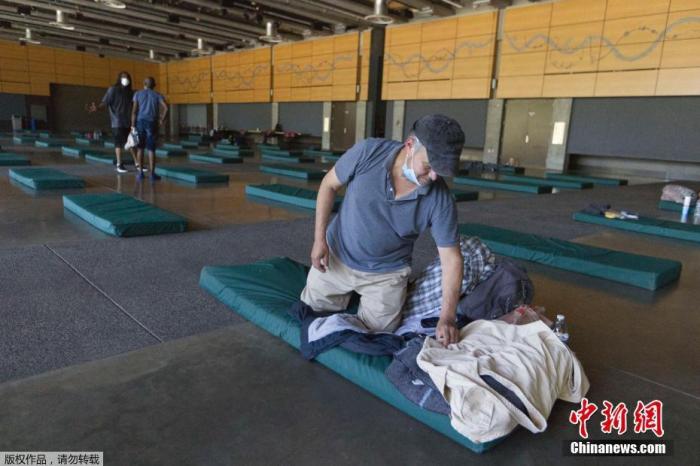 资料图：美国俄勒冈州波特兰市，一名男子在紧急避难中心避暑。